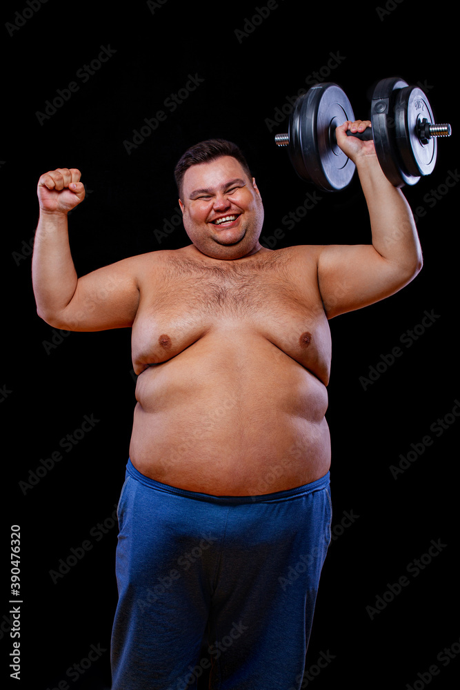 Fat man doing workout traning with dumbbells. Happy guy isolated over yellow background. Fat man doing workout traning with dumbbells. Happy guy isolated over yellow background.