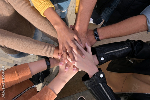 The team's hands are folded together as a symbol of union. Multinational group