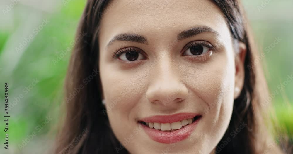 Close up shot of Caucasian cheerful young woman face smiling to camera in good mood. Beautiful joyful female florist looking at camera with happiness. Positive emotions concept. Blurred background Close up shot of Caucasian cheerful young woman face smiling to camera in good mood. Beautiful joyful female florist looking at camera with happiness. Positive emotions concept. Blurred background