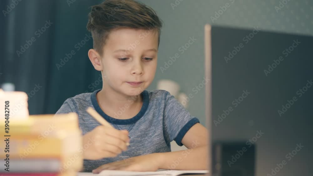 Little boy is nodding while having an online lesson at home Little boy is nodding while having an online lesson at home