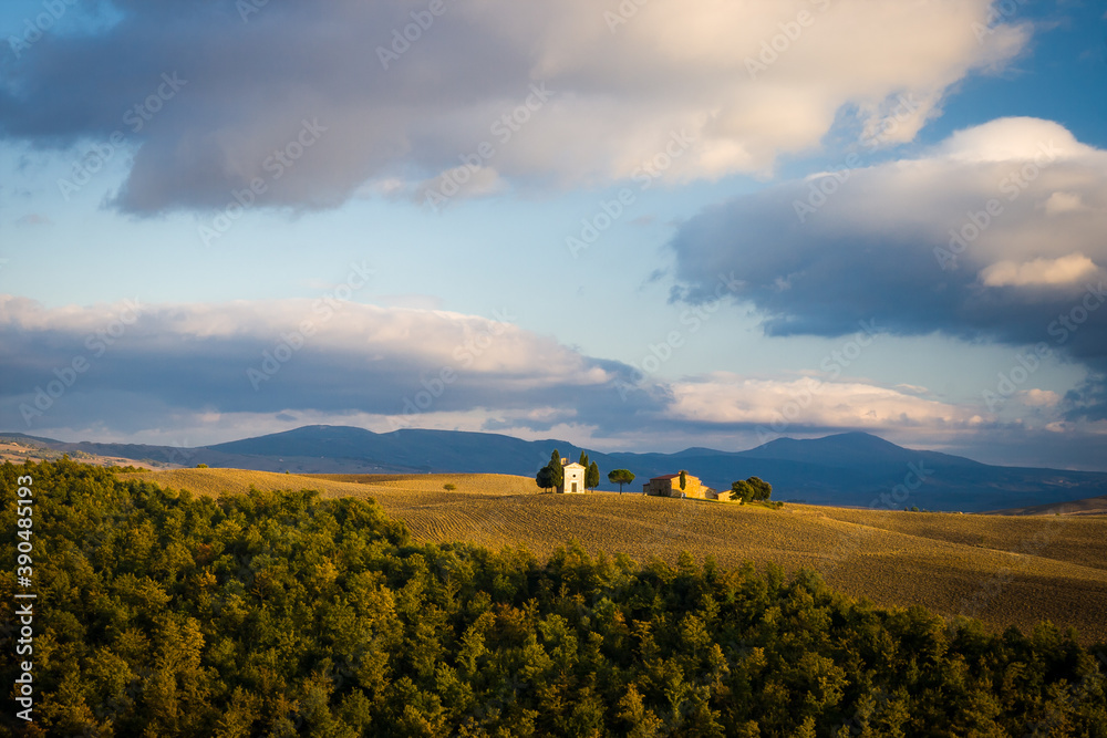 Obraz premium small chapel in autumn landscape, brown fields with heavy clouds, italy, tuscany