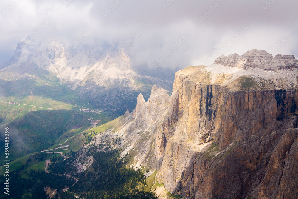 spectacular mountains in nice light coming over clouds, view to the valley from the top, italy, dolomites