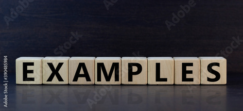 Concept word 'examples' on wooden cubes on a beautiful darl wooden background. Wooden table. Copy space. Business concept. photo