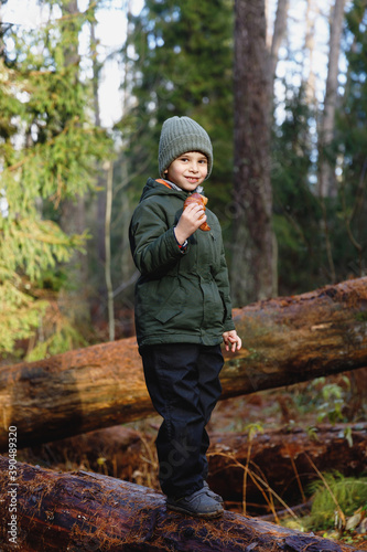 snack on a walk in the woods. little boy with croissant in nature