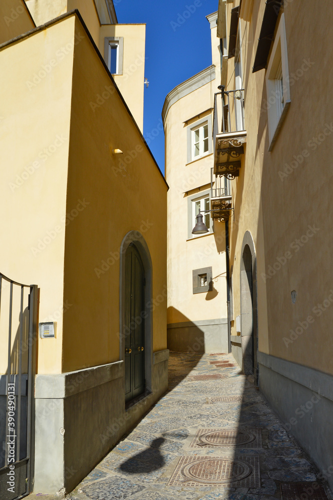 A narrow street between the old houses of Pozzuoli, a town in the province of Naples, Italy.