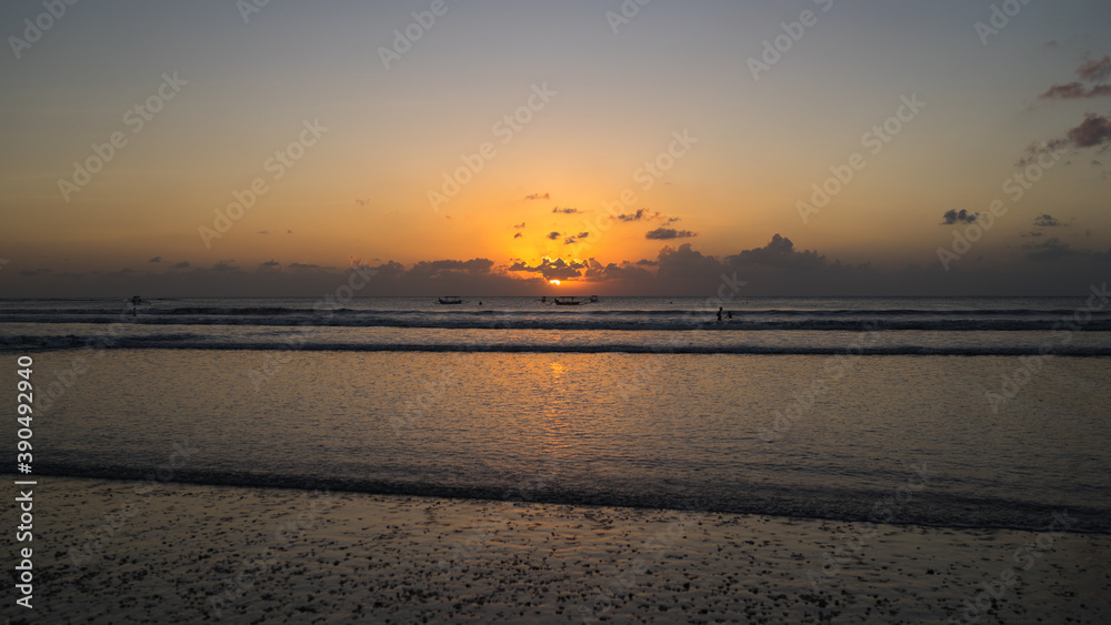 Beautiful golden sunset over the sea in Kuta beach, Bali Island, Indonesia. Freedom and spirituality concept, meditation on the beach, beautiful destination