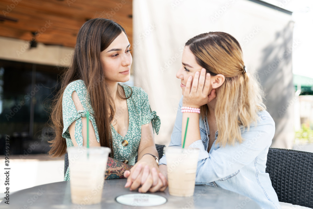 Young gay couple sitting face to face in a coffee date Young gay couple sitting face to face in a coffee date