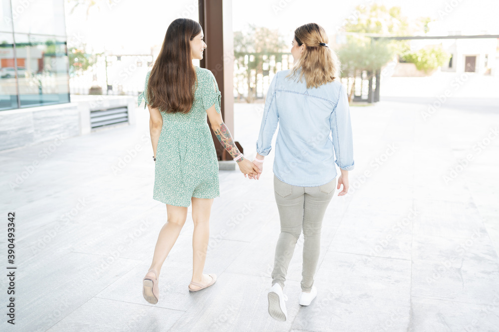 Two young lesbians walking from behind