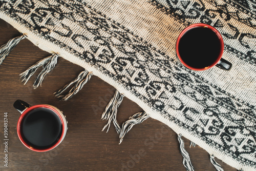 Top view of two coffee glasses on a wooden table. The tablecloth fabric. Warm atmosphere.