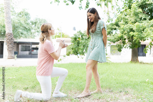 Young woman on one knee proposing to her partner