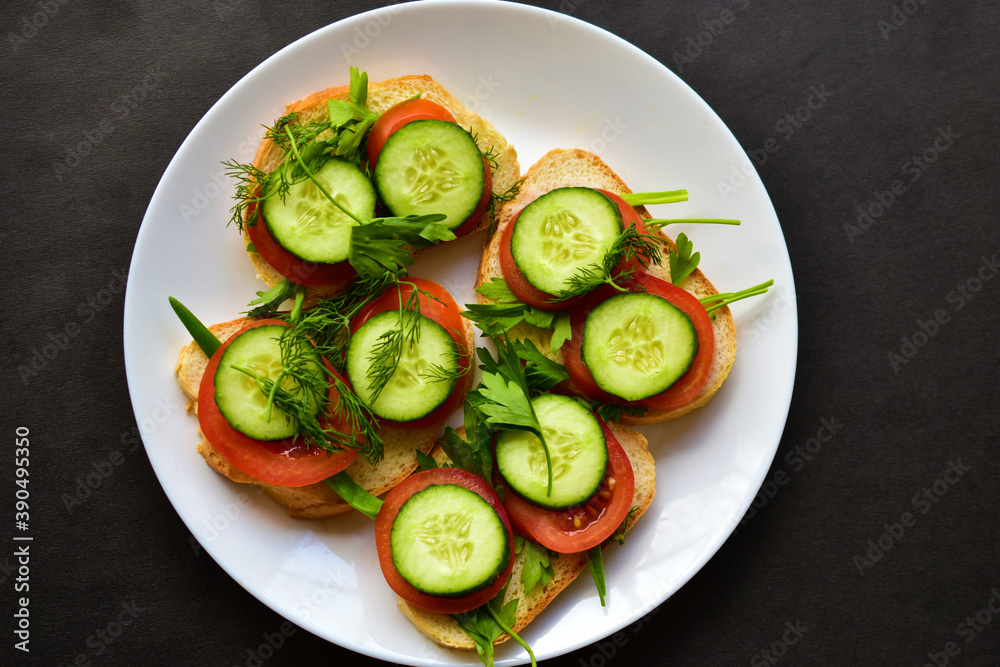 Diet sandwiches with greens, cucumber and tomato on a white plate Diet sandwiches with greens, cucumber and tomato on a white plate