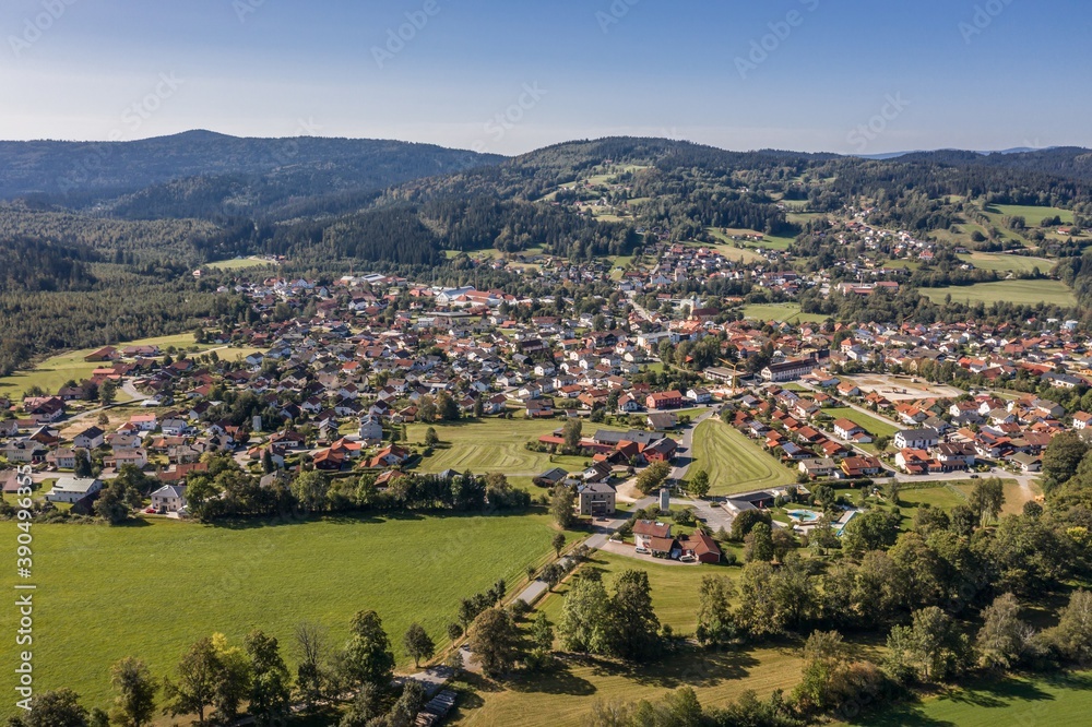 Bild einer Luftaufnahme der Gemeinde Frauenau im bayerischen Wald mit Landschaft und Bergen im Hintergrund, Deutschland