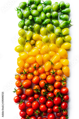 The harvest of tomatoes. Different color and varieties of tomatoes on a white background. Healthy and natural food. Vertical