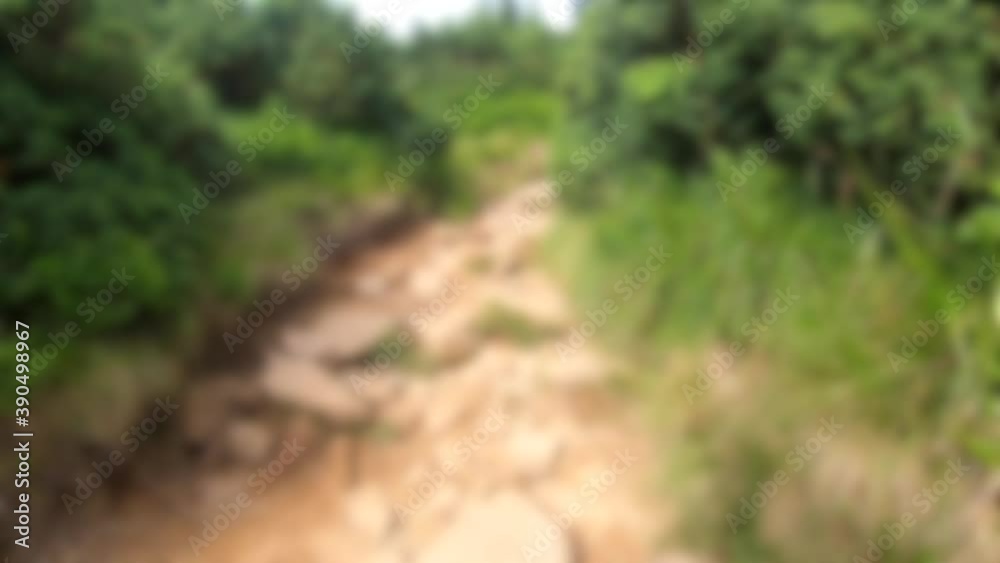 Blurred background. People walk on dirt mountain trail while hiking in mountains Blurred background. People walk on dirt mountain trail while hiking in mountains