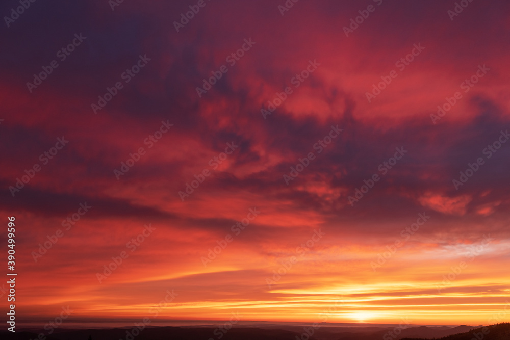Fiery orange sunset sky. Dramatic sky with red glowing clouds. Natural background for your landscape project