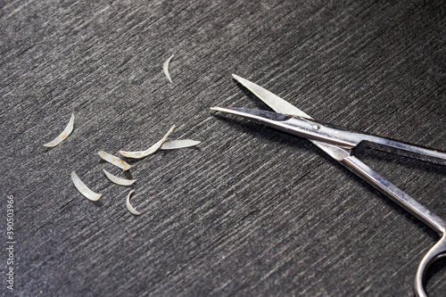 Cut nails and scissors lie on wood background.