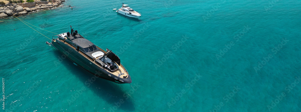 Aerial drone ultra wide photo of luxury yacht with wooden deck anchored in tropical exotic island bay wit turquoise sea Aerial drone ultra wide photo of luxury yacht with wooden deck anchored in tropical exotic island bay wit turquoise sea