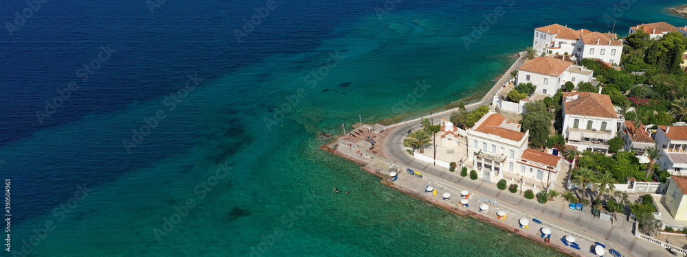 Aerial drone ultra wide photo of small chapel of Agios Mamas and three cannon monument in picturesque old seaside town of Spetses island, Saronic gulf, Greece