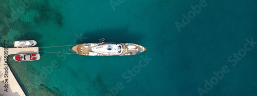 Aerial drone top down ultra wide photo of luxury yacht anchored in tropical exotic island turquoise sea