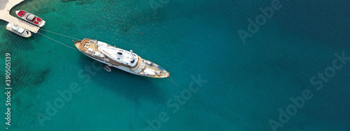 Aerial drone top down ultra wide photo of luxury yacht anchored in tropical exotic island turquoise sea