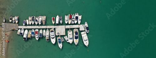 Aerial drone top down ultra wide photo of small Mediterranean port with anchored yachts