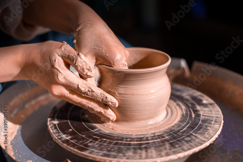 Potter's wheel and the hands of an artisan. Close-up.