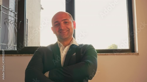 Professional businessman looking at camera standing on stairs in corporate finance building. Entrepreneur, leader, manager, office executive posing in office on staircase. photo