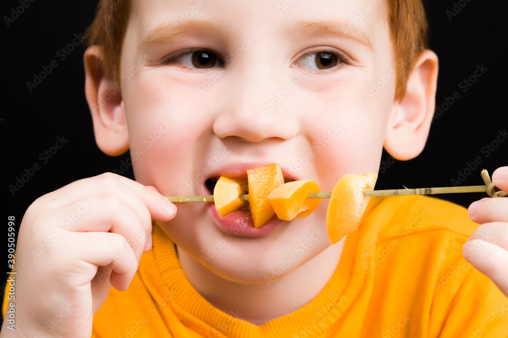 beautiful red-haired boy with delicious sliced peach beautiful red-haired boy with delicious sliced peach