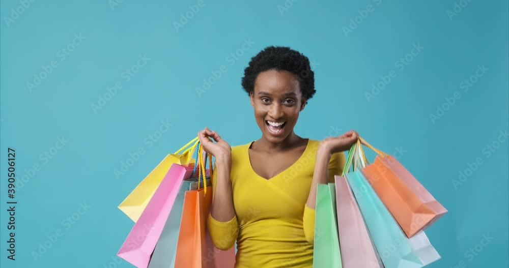 Excited african american woman dancing with shopping bags in her hands
