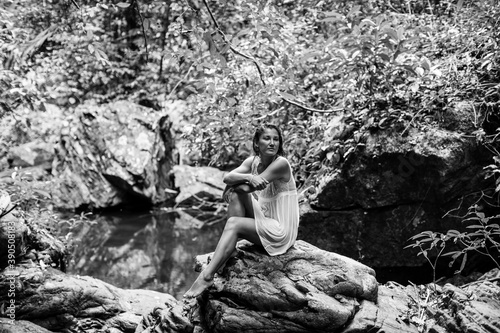 Young woman near a waterfall. Thailand. Black and white photo.