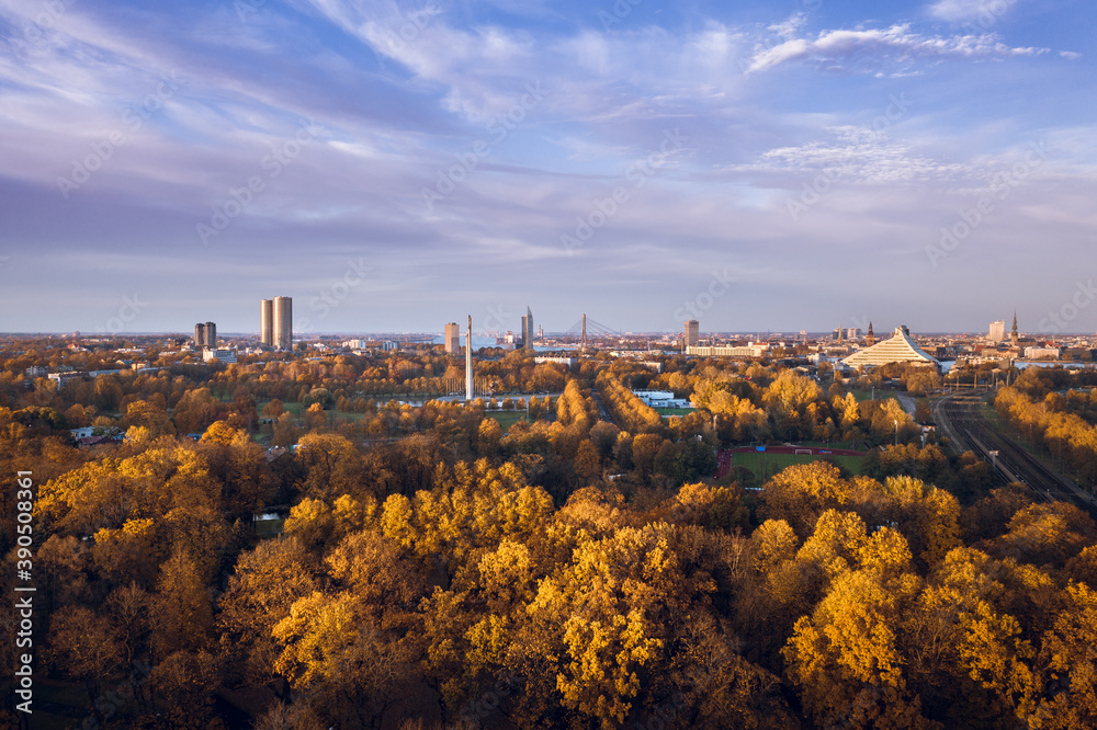Obraz premium Aerial view of Riga city at colorful sunset. Beautiful architecture, impressive trees in autumn colors. Sustainable city.