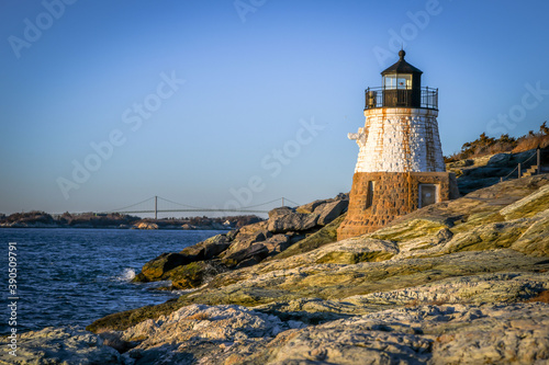 A small lighthouse hugs the Rhode Island shore