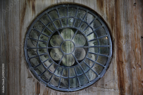 lead and glass round window set in an old wood door