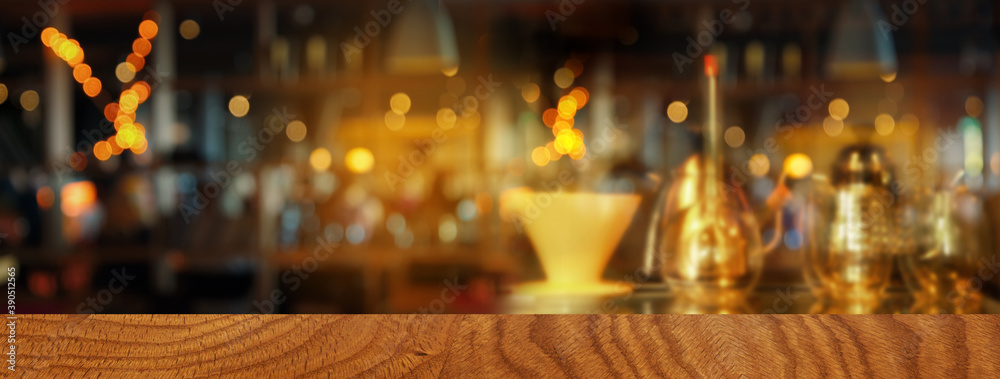 top of wood table with blur light of coffee bar or cafe night party banner background