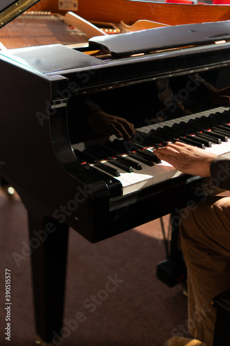 A pianist is finishing a Christmas song on a grand piano.
