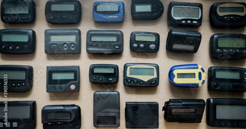  many, a lot  old a black pagers or beepers  on wooden  background. front view. photo