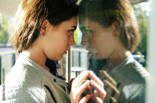 Obraz na plátně Self reflection portrait of amazing young girl in mirrored window