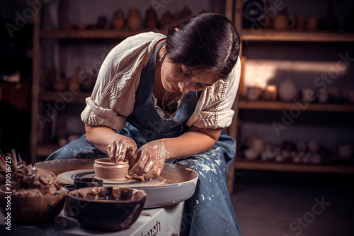 Young female potter working on a potter's wheel.