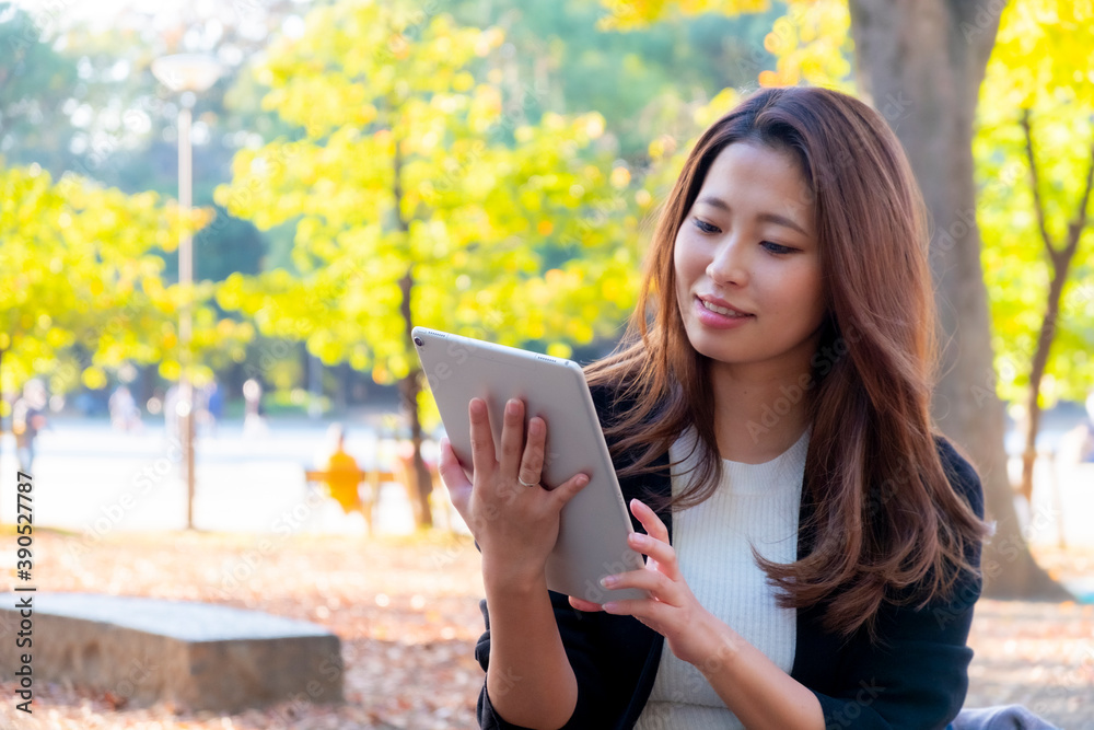 Fototapeta premium 【東京都】屋外でタブレットを操作する女性【2020年 紅葉】