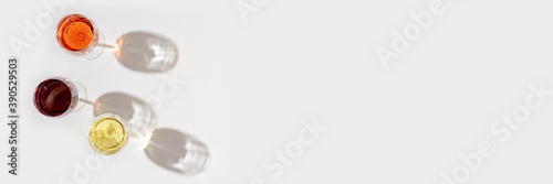 Set of wine in glasses with beautiful shadows. Banner with red, rose and white wine