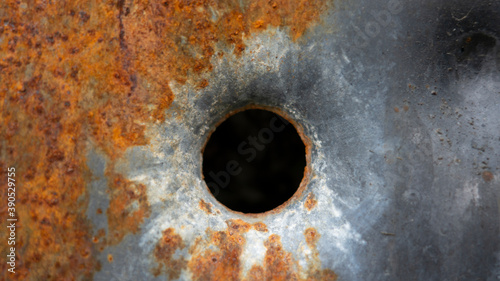 Bullet hole on the rusty metal surface