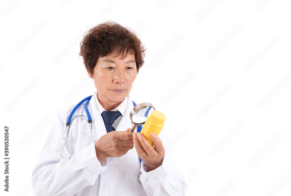 Chinese old doctor is looking at medicine bottle with magnifying glass in front of white background Chinese old doctor is looking at medicine bottle with magnifying glass in front of white background