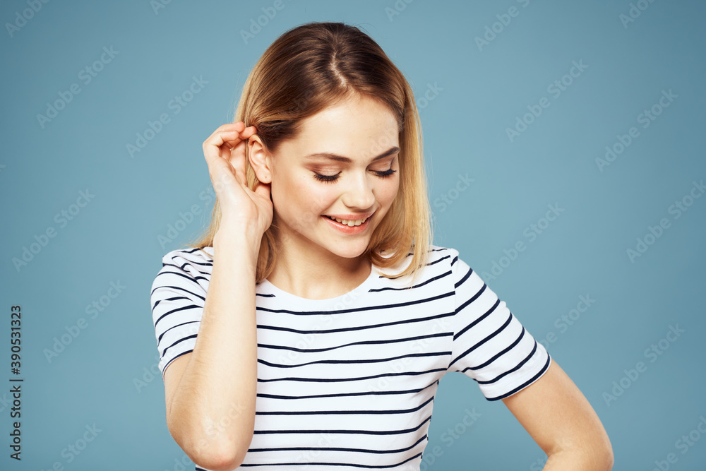 Blonde girl in striped t-shirt lifestyle blue background fun Blonde girl in striped t-shirt lifestyle blue background fun
