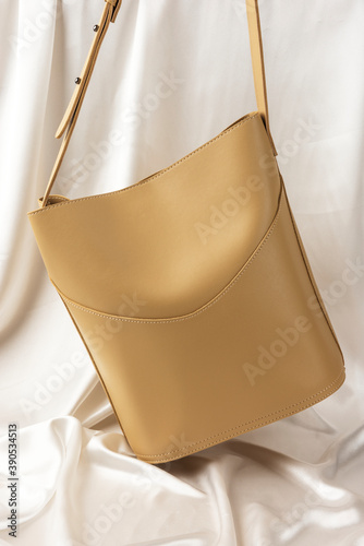 Beige shoulder bag mockup against a white sheet