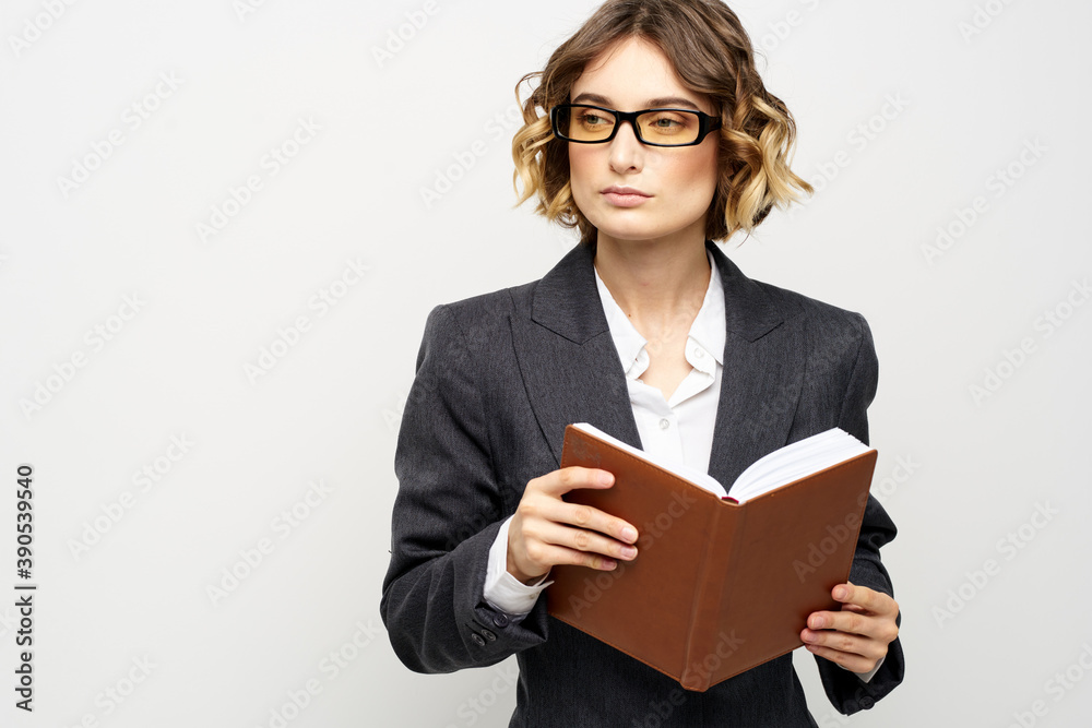 Business woman in a classic suit with a notebook in her hand and glasses on her face Copy Space