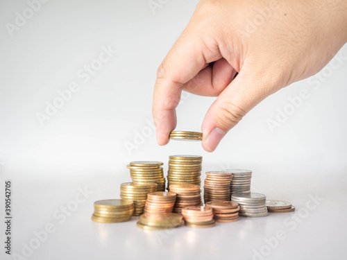 The hand was picking up the money that had been stacked up in layers. White background