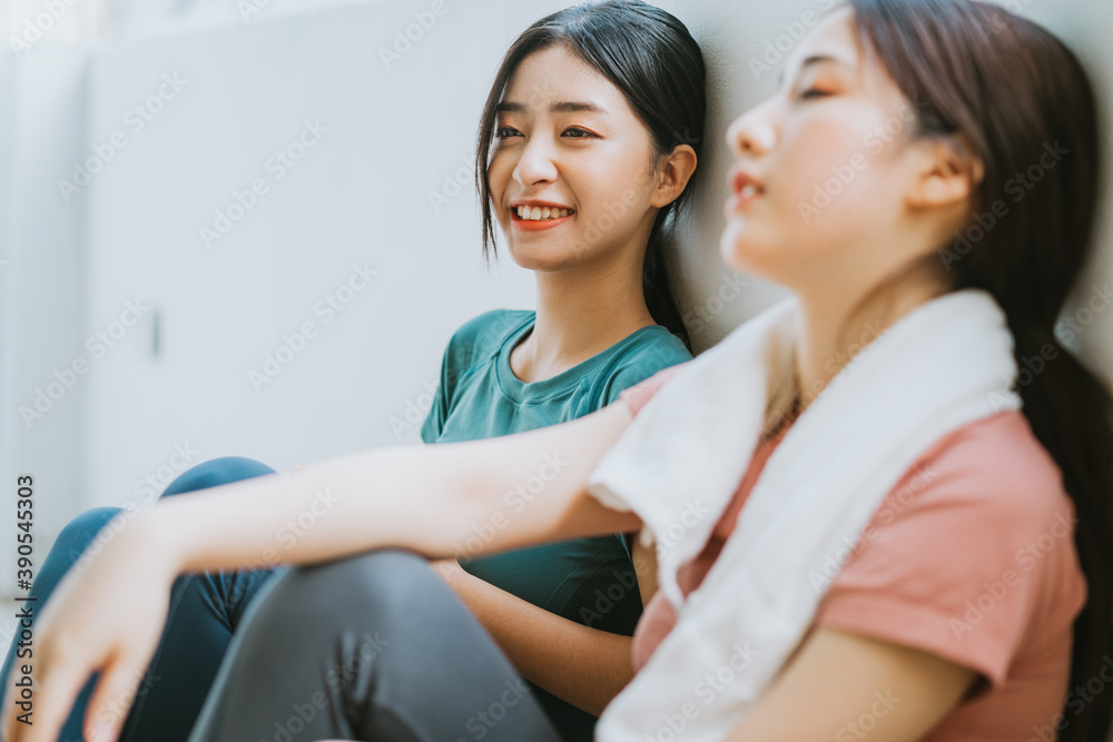 Two Asian women taking a break from yoga session
Two Asian women taking a break from yoga session