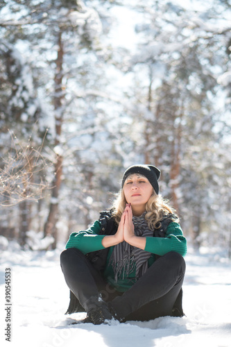 Beautiful woman sits in frozen park. Tranquility and yoga concept with copy space. © Sir