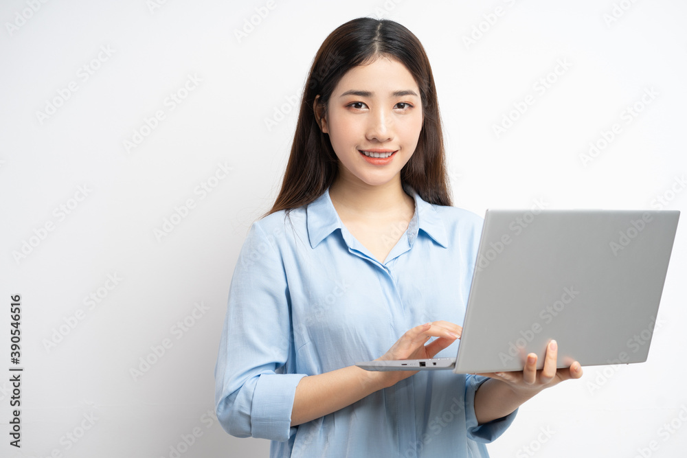 Asian woman holding a laptop in her hand
Asian woman holding a laptop in her hand