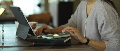Female freelancer hand working with digital tablet, notebook and smartphone